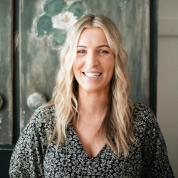 Blonde woman in a grey sweater smiling