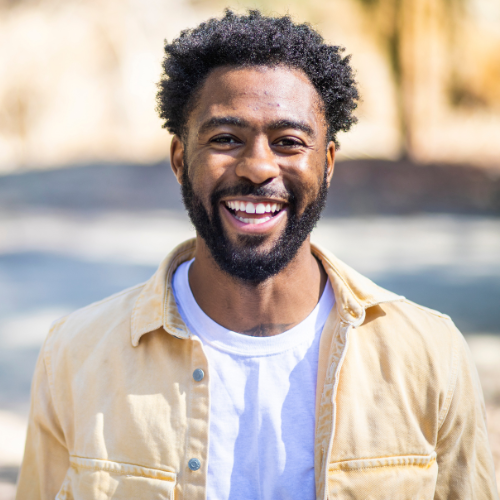 Man smiling at camera in yellow shirt